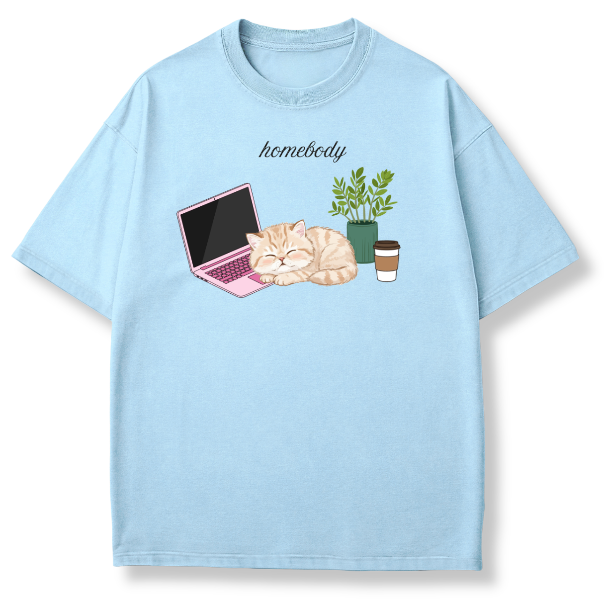 A light blue short-sleeve t-shirt with a graphic print of a sleeping orange tabby cat next to a pink laptop, a potted plant, and a takeaway coffee cup, with the word 'homebody' printed above.
